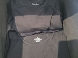 two shirts in a box that are sitting on the floor