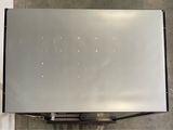a silver refrigerator that is on the floor in a room
