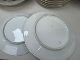 many plates on the table with a lot of saucers on them
