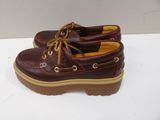 men ' s brown leather boat shoes with brown soles on a white surface