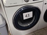 a washer and dryer in a room with tile flooring