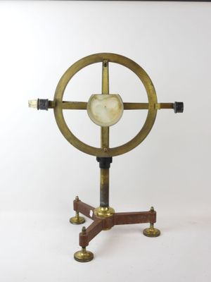 a gold and black clock on a stand on a white background
