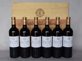 six bouteilles de vin sont alignées devant une caisse en bois