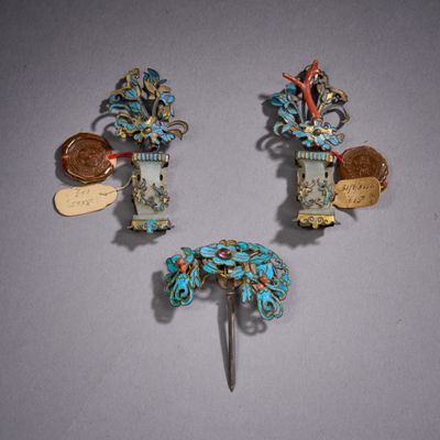 trois broches de couleur argentée et turquoise sur un fond gris