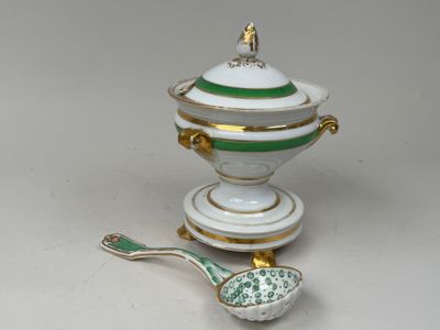 un bol vert et blanc et une cuillère posés sur une table