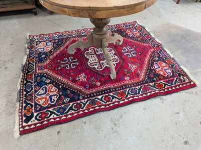 une petite table avec un plateau en bois sur un tapis