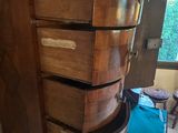 a tall wooden cabinet with drawers on top of it