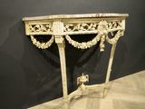 a white table with a marble top and gold decorations on it