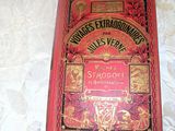 an old red book sitting on top of a table next to a ruler