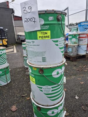 une pile de fûts verts et blancs sur lesquels est apposée une étiquette de prix