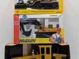two boxes of toy construction equipment on a white surface