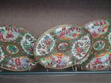 three chinese plates are on display in a glass case