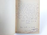 an open book with a handwritten letter on it sitting on a table