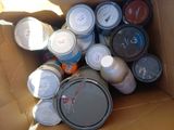 many cans of paint sitting in a cardboard box
