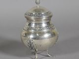 an antique silver plated urn with a bird on it