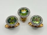 trois bagues en topaze verte et blanche, ornées de diamants, sur un fond blanc