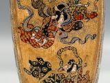 a gold vase with a picture of a woman and a dragon on it