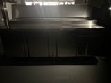 a large stainless steel counter in a kitchen with a window