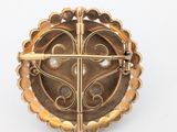 an image of a gold broochle with a cross on it