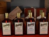 three bottles of wine sitting on top of a table next to wooden boxes