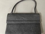 grey leather purse with strap on a white surface