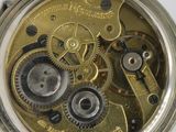 a close up of a pocket watch on a white surface
