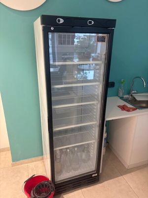 un réfrigérateur qui se trouve dans le coin d'une pièce