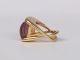 a close up of a gold ring with a purple stone