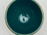 a green bowl with a white design on it