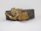 a statue of a person laying down on a book
