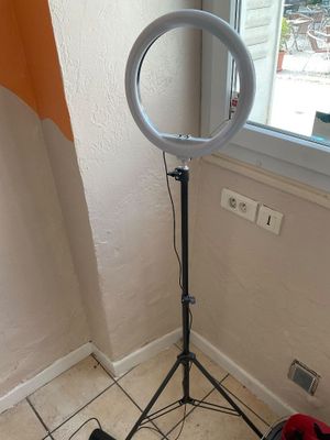 une lampe posée sur un trépied dans une pièce