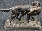 bronze statue of a dog carrying a duck in its mouth