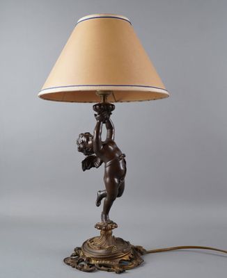 une lampe en bronze sur laquelle est représenté un Cupidon tenant une fleur dans son bras