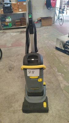 un aspirateur gris et jaune posé sur le sol