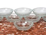 six bols en verre posés sur une table recouverte d'une nappe rouge