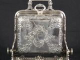 a silver plated box with a handle and handle on a stand