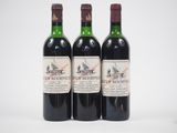 trois bouteilles de vin rouge posées l'une à côté de l'autre sur une surface blanche