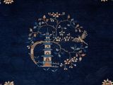 an image of a blue rug with a tree and a bird on it