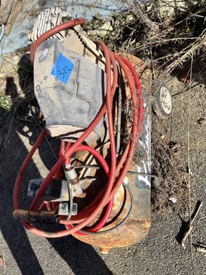 a red hose attached to a rusty piece of equipment