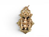 a close up of a gold and black broochle on a white background