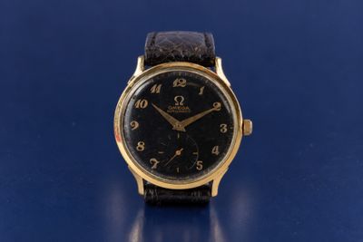 an image of a gold wrist watch on a blue surface