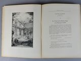 an open book on a table with a drawing of a building in the background