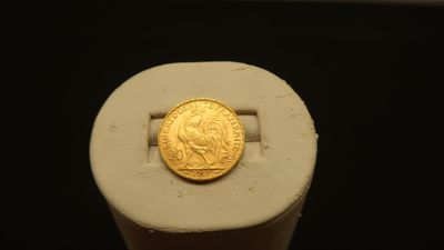 an image of a gold coin sitting on top of a piece of paper