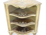 a small corner cabinet with three shelves on it