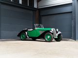 a green and black car parked in front of a garage