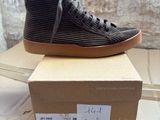 black and brown high top sneakers on top of a cardboard box