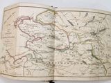 an open book with a map on it sitting on top of a table