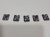 four small pieces of black and white electronic components on a white surface