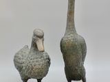 une paire de canards en bronze sur pied, placés côte à côte sur un fond blanc