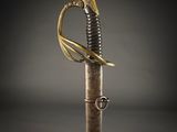 a close up of a sword with a gold handle on a black background